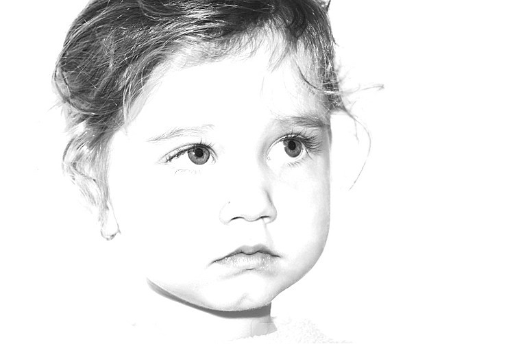 a small child with one eye closed in front of a white background