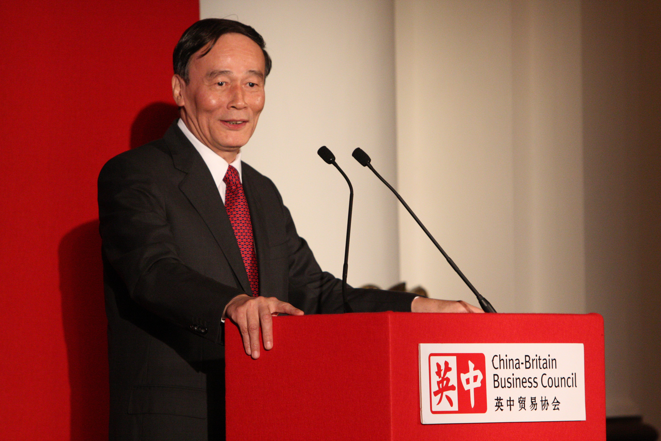 asian businessman speaking at podium during public event