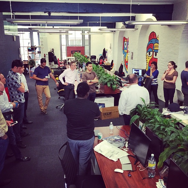 some office workers at desks playing wii