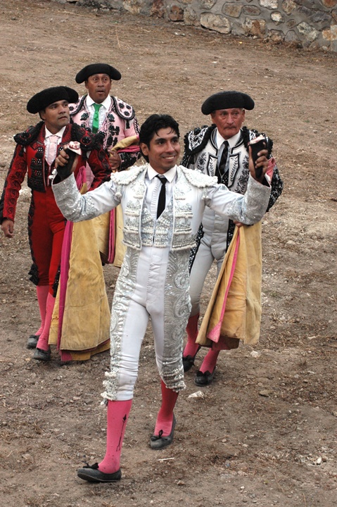 three women wearing white and colorful outfits in dirt area