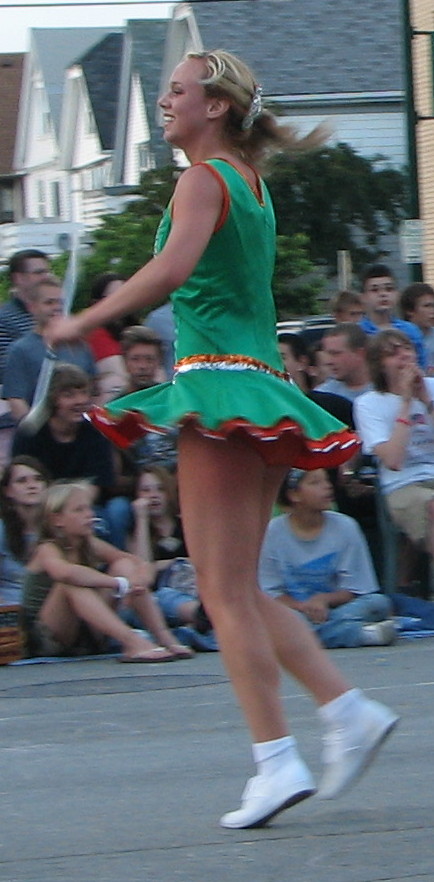 a woman in a dress is standing by the street