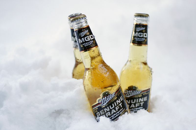 two bottles of beer sitting on top of the snow