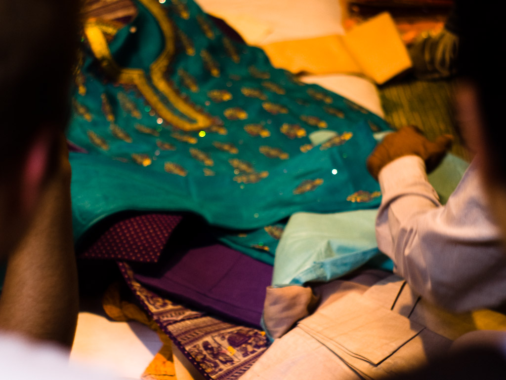 a man is grabbing soing on top of a pile of clothing