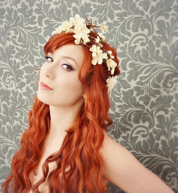 a girl wearing a white flowered head wreath with red hair