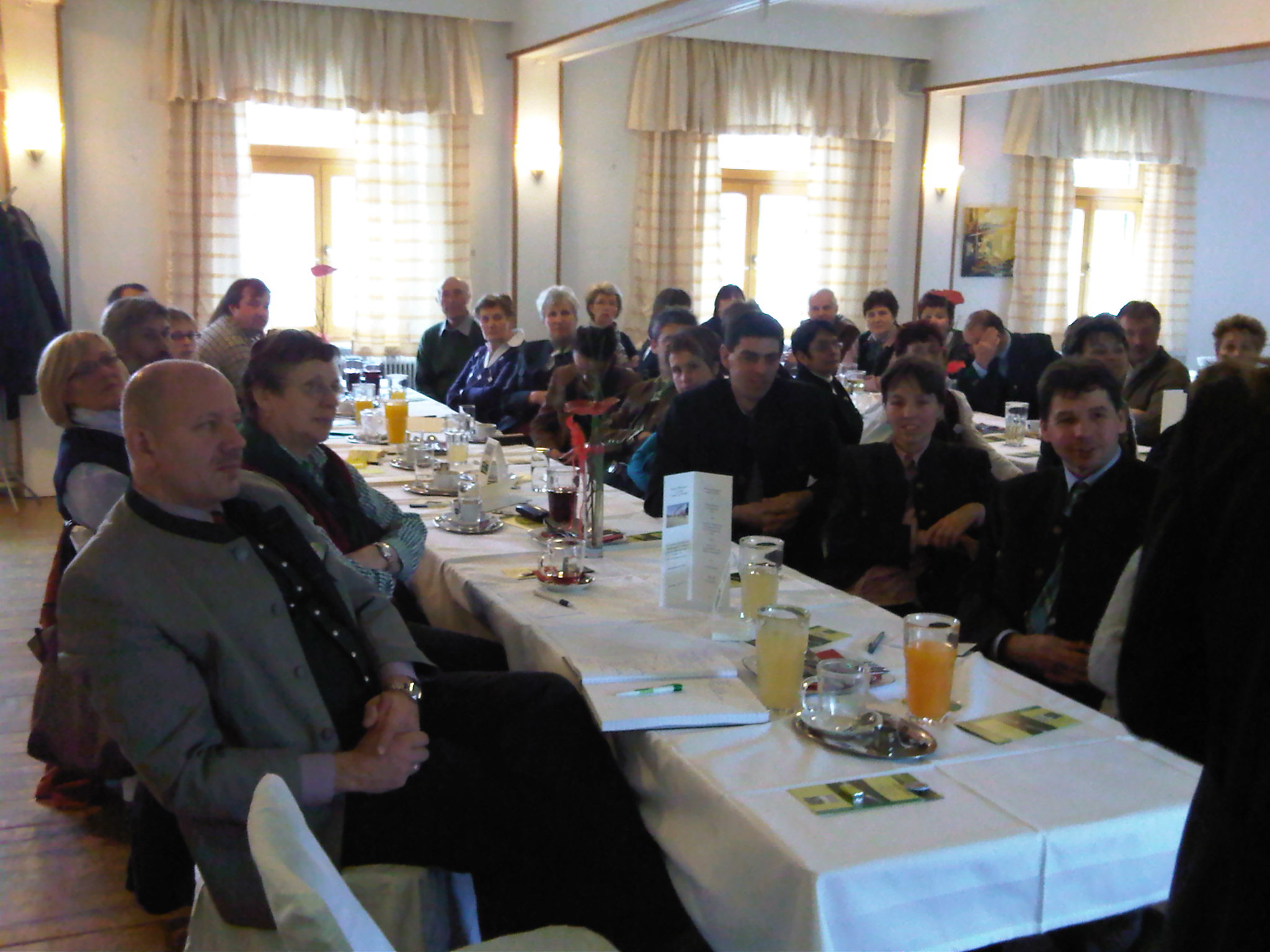 a large group of people are sitting at long tables