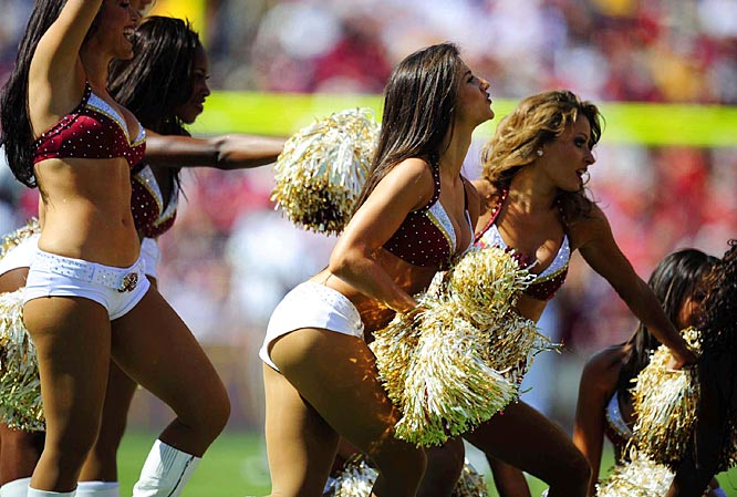 cheerleaders in uniforms performing on a football field