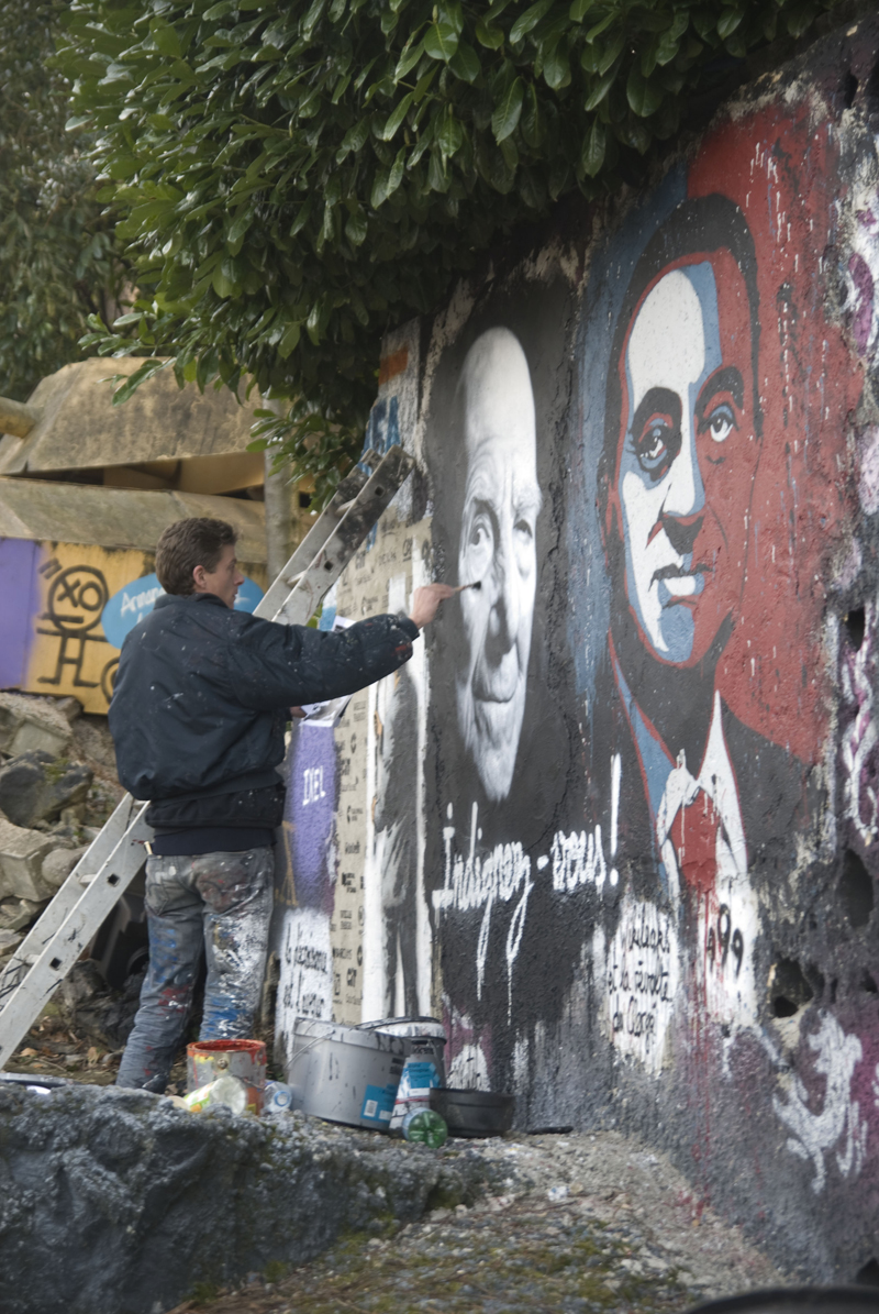 a man painting graffiti on the side of a wall