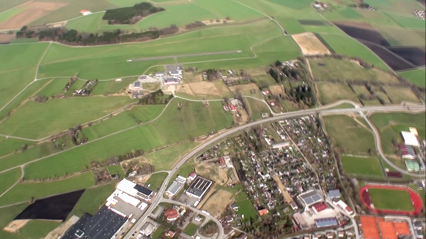 a large grassy field surrounded by buildings