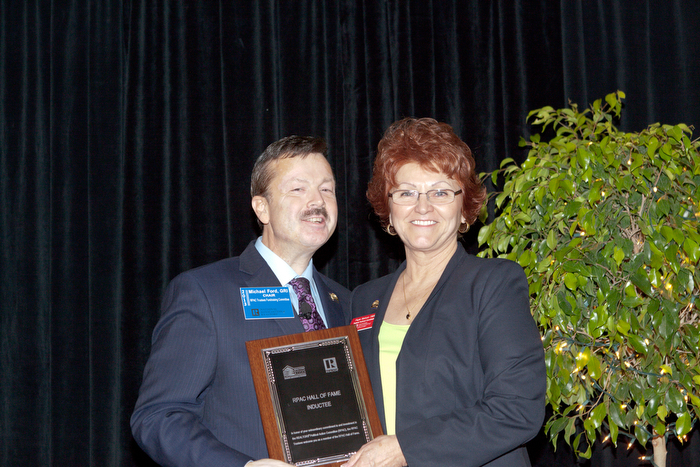 a man and woman posing with an award