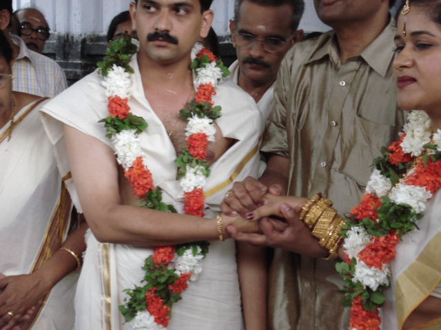 a man getting married wearing orange flowers