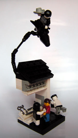 a lego robot sitting on top of a stove