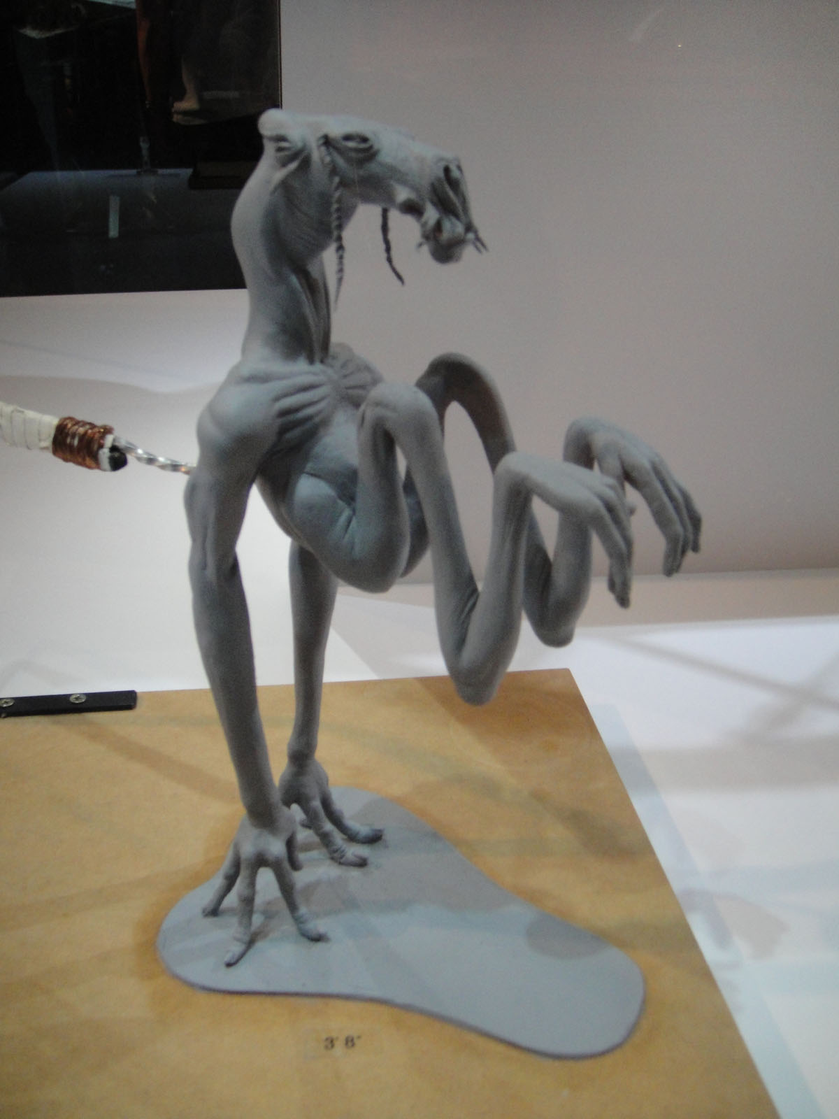 a sculpture of an alien looking creature with an electronic light next to it