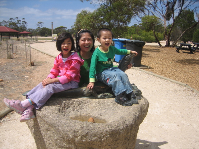 two children are sitting on a rock and laughing
