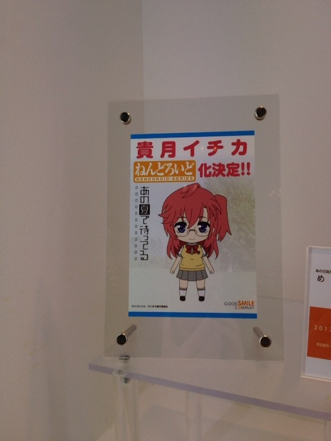 a poster on a wall next to a glass shelf