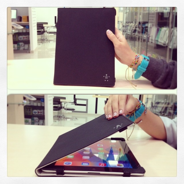 a hand is holding a tablet and a black piece of the ipad