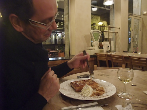 a person sitting at a table eating a plate of food