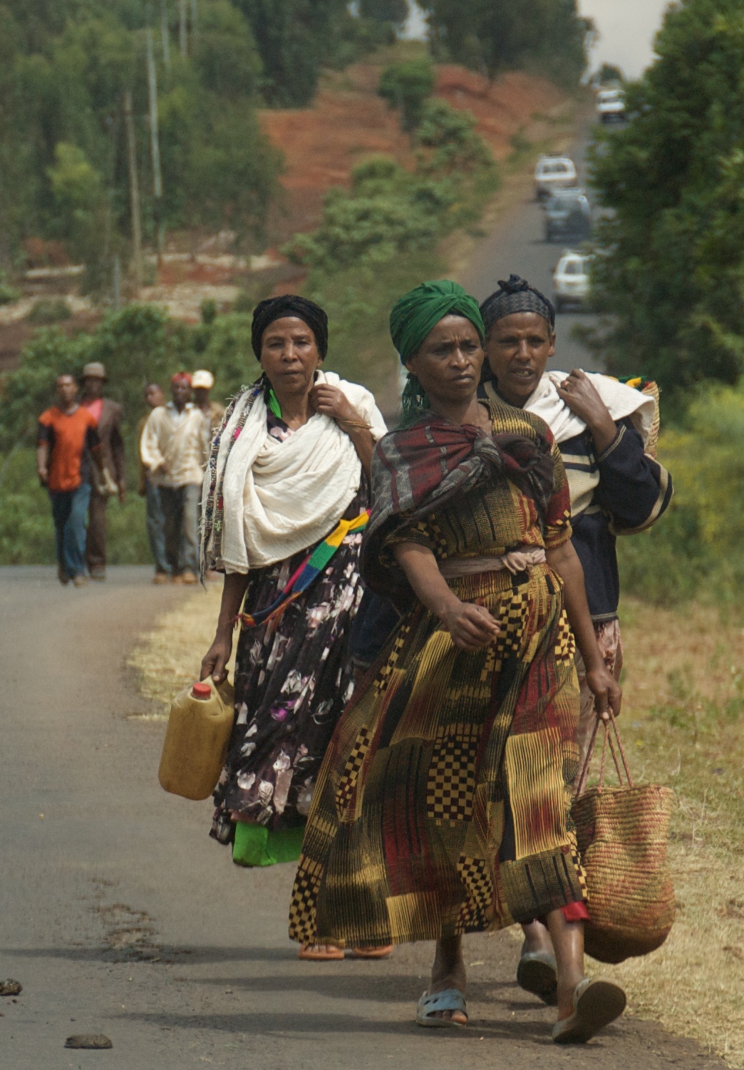a group of women walking down the road together