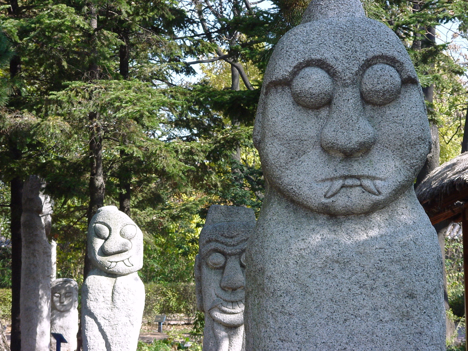 a large gray statue next to some trees