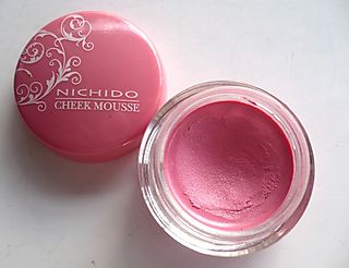pink eye liner in jar with lid on white surface
