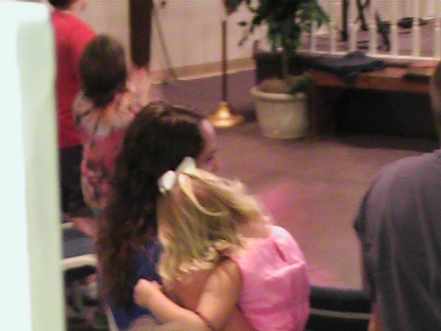 two girls hug each other in a small chapel
