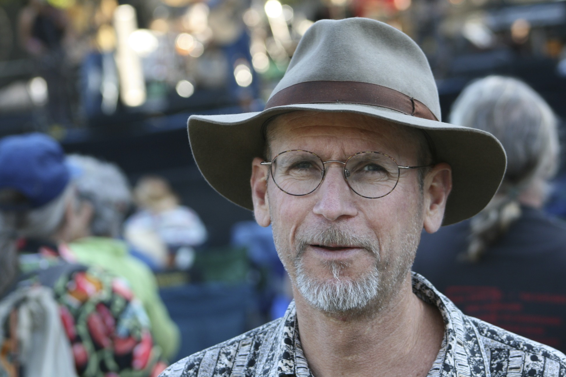a man in glasses, hat and glasses looking at the camera
