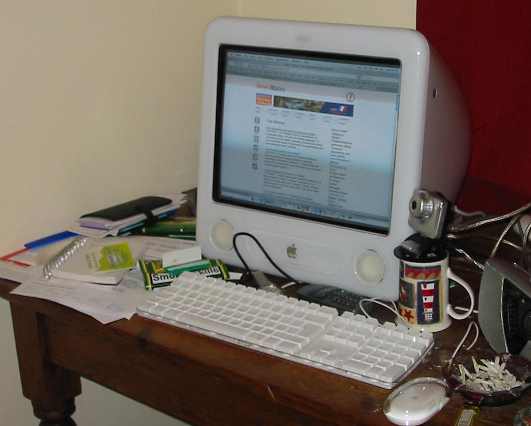 a desk with an apple computer and other gadgets
