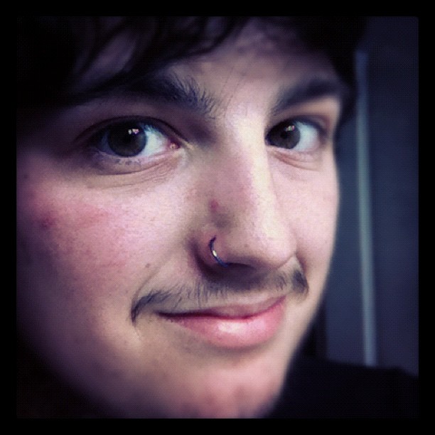 a man with the nose ring has a mustache on it