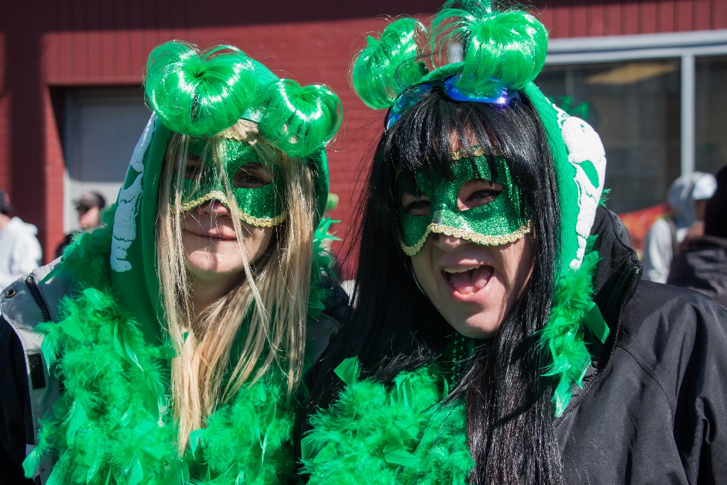 two women wearing green and white outfits in a parade