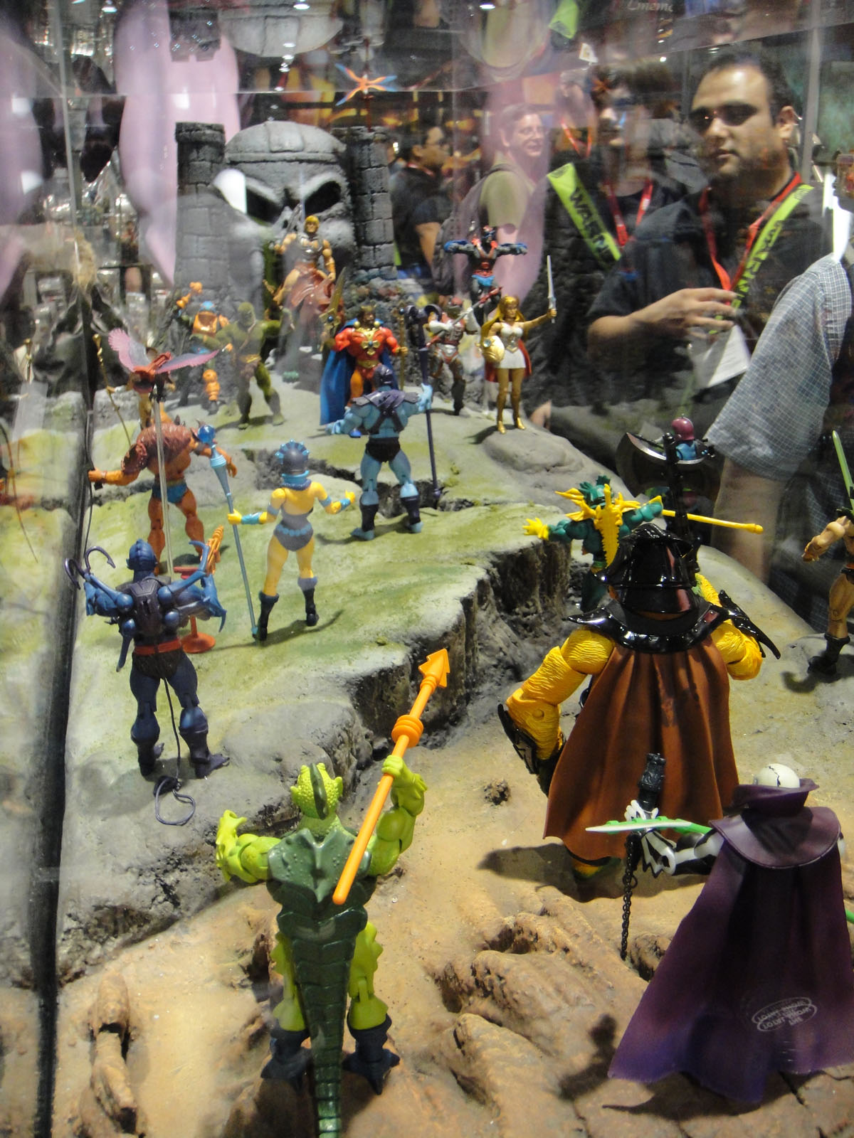 people looking at toy figures on display in a glass case