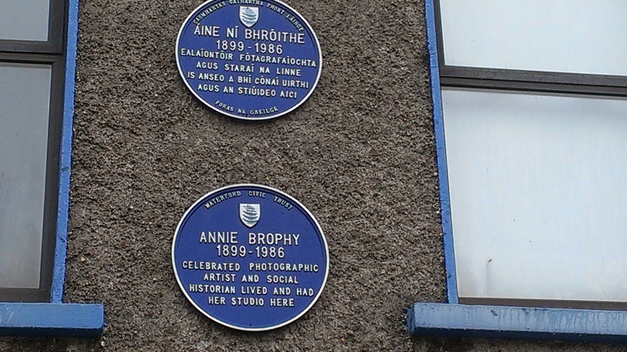 two blue plaque on the side of a building