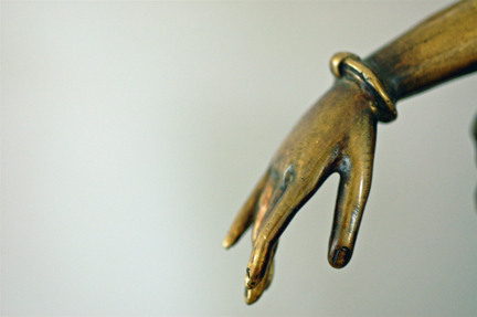 a golden statue has a hand with an outstretched arm