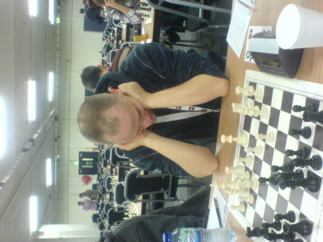 a man in a black t - shirt is playing chess