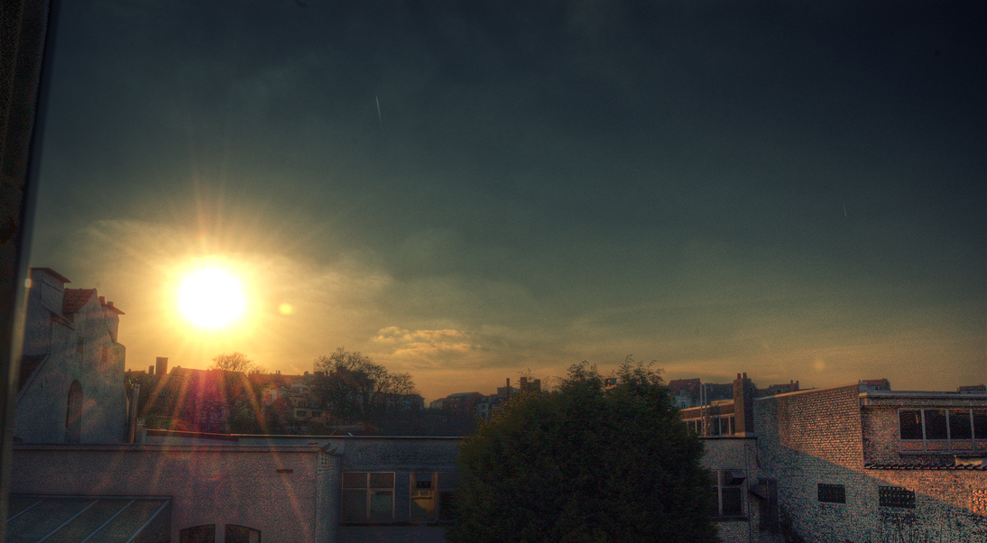 an outside view of buildings and a bright sun shining