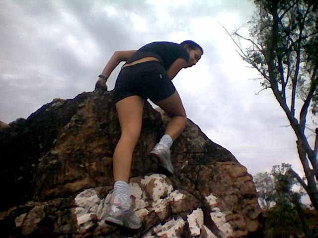 a woman wearing black and gray running clothes on a rocky mountain