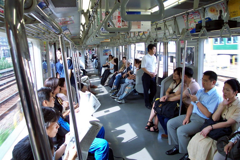 people sit on a public transportation car during the day