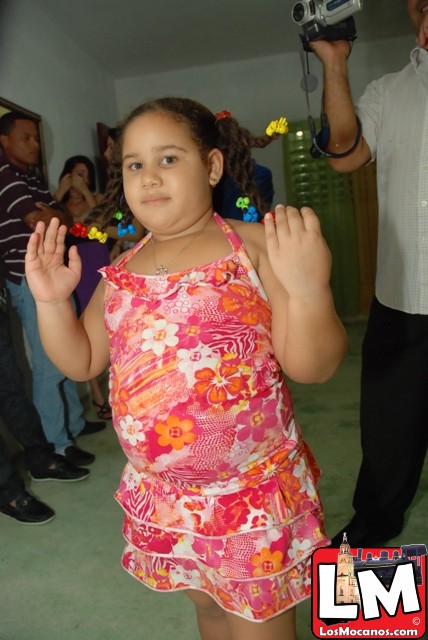 a little girl in a pink dress is standing