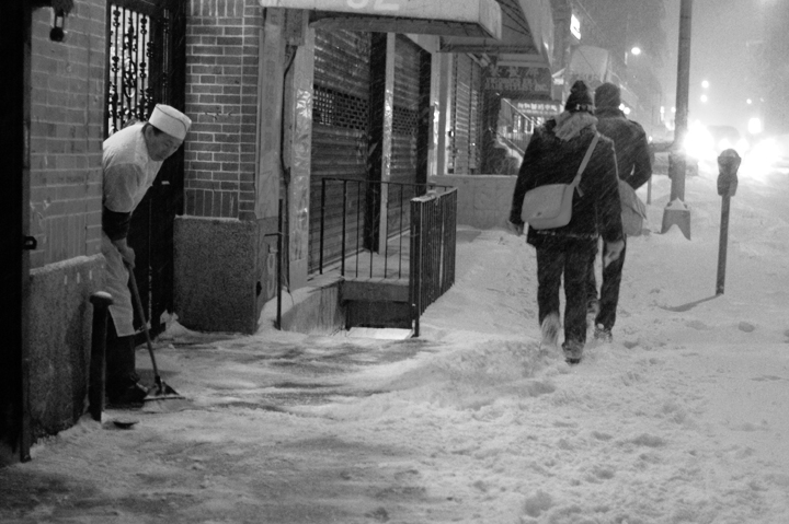 a group of people walking across a snow covered street