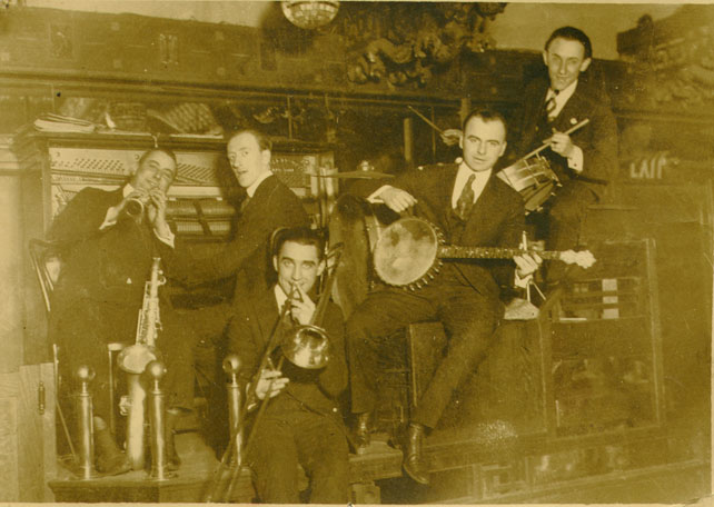 several men standing around holding up instruments