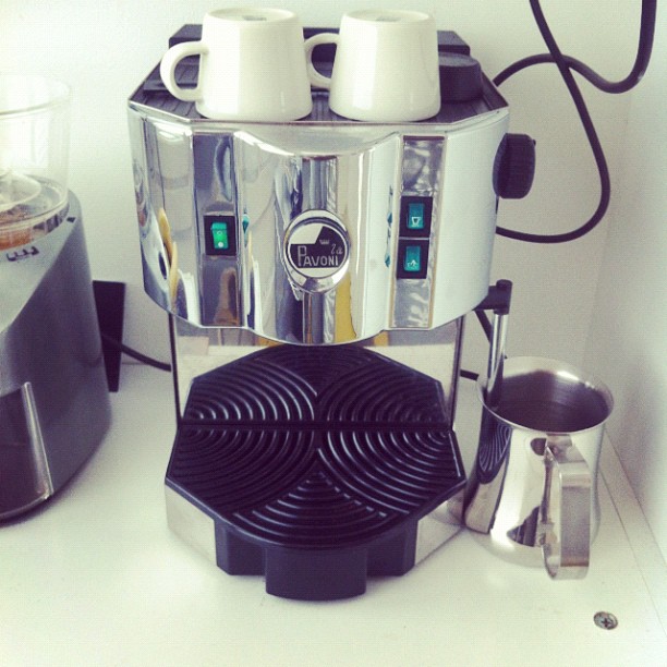 a coffee maker with its four cups placed in front