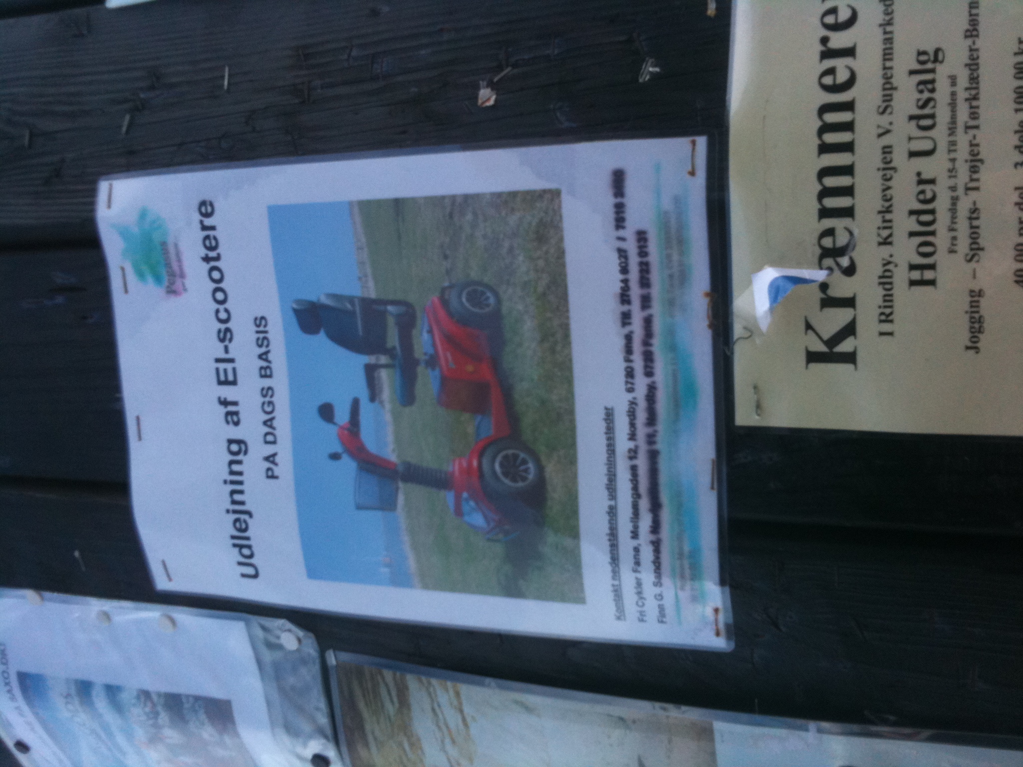 a group of brochures hang on a wall next to a fence