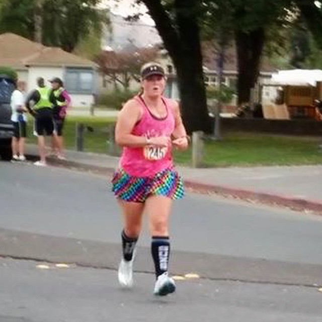 a woman running down the road in a colorful skirt