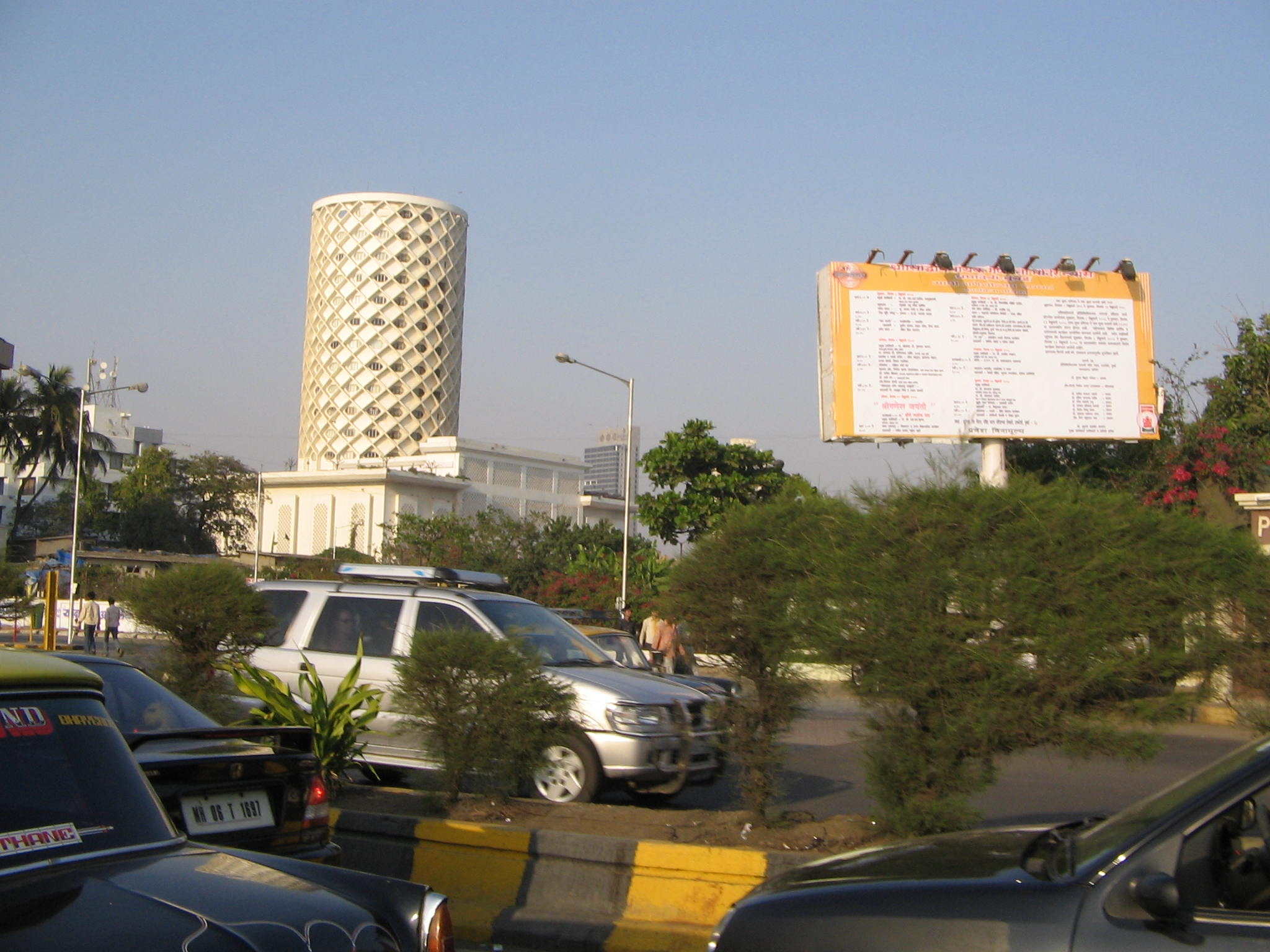 a large billboard on a building next to a parking lot with cars parked