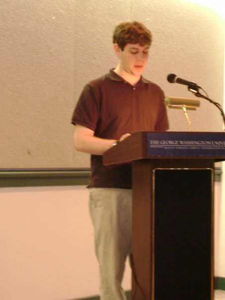a man is standing in front of a podium with microphones