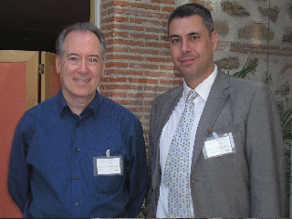 two men standing next to each other with cards in their hand