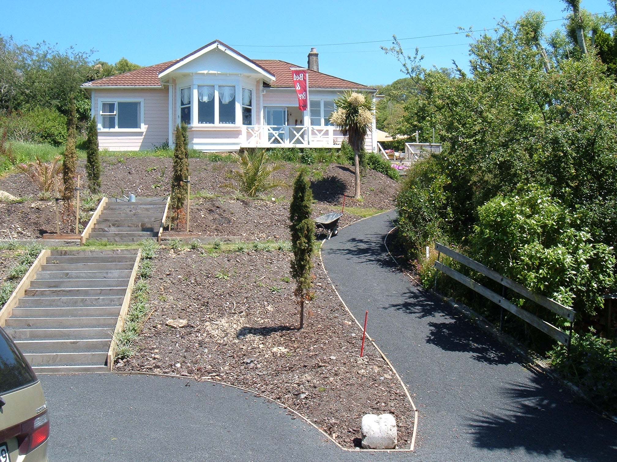 the house is situated next to a grassy area and an empty driveway