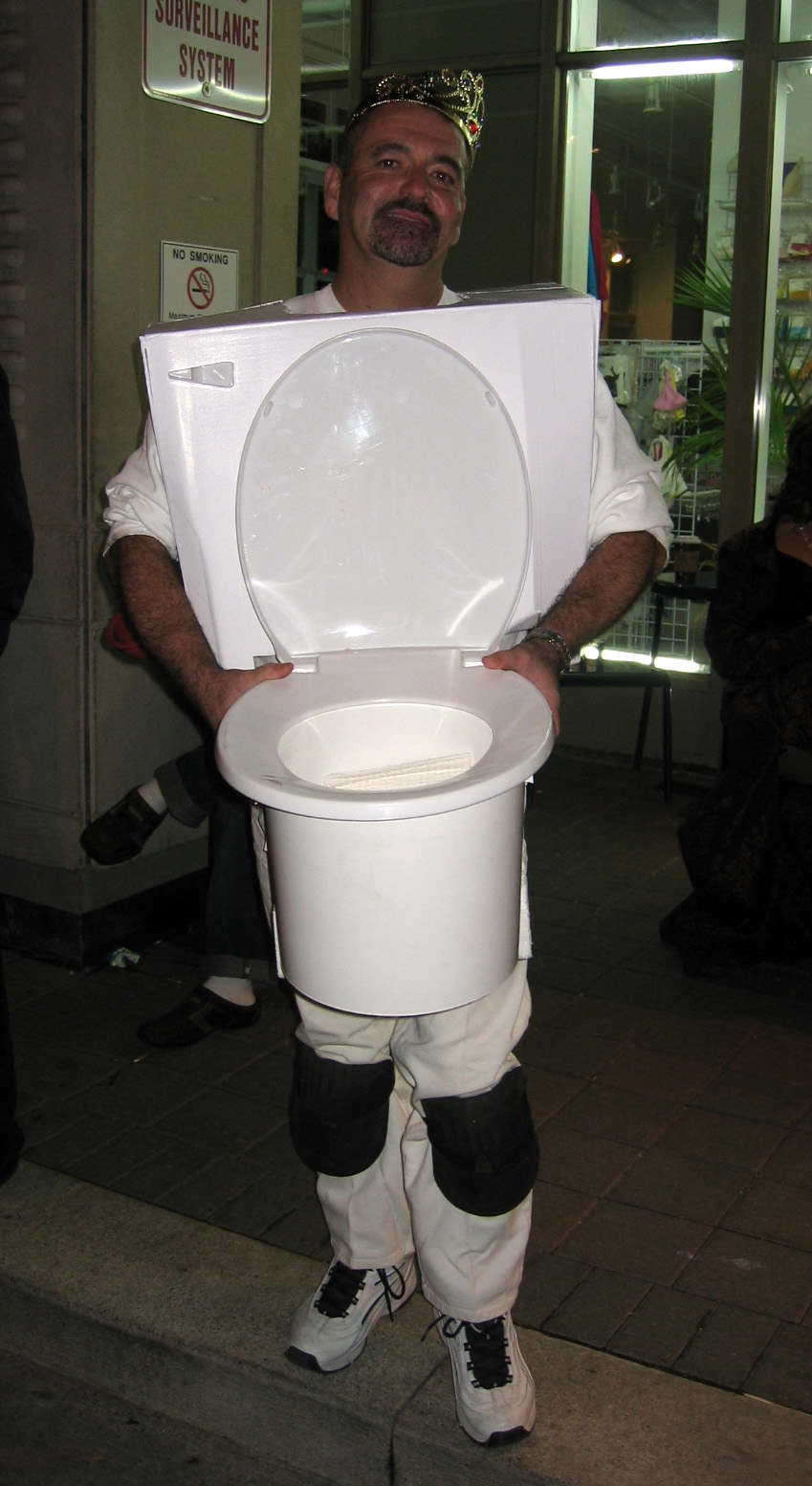 a man dressed as a soccer referee holding a toilet