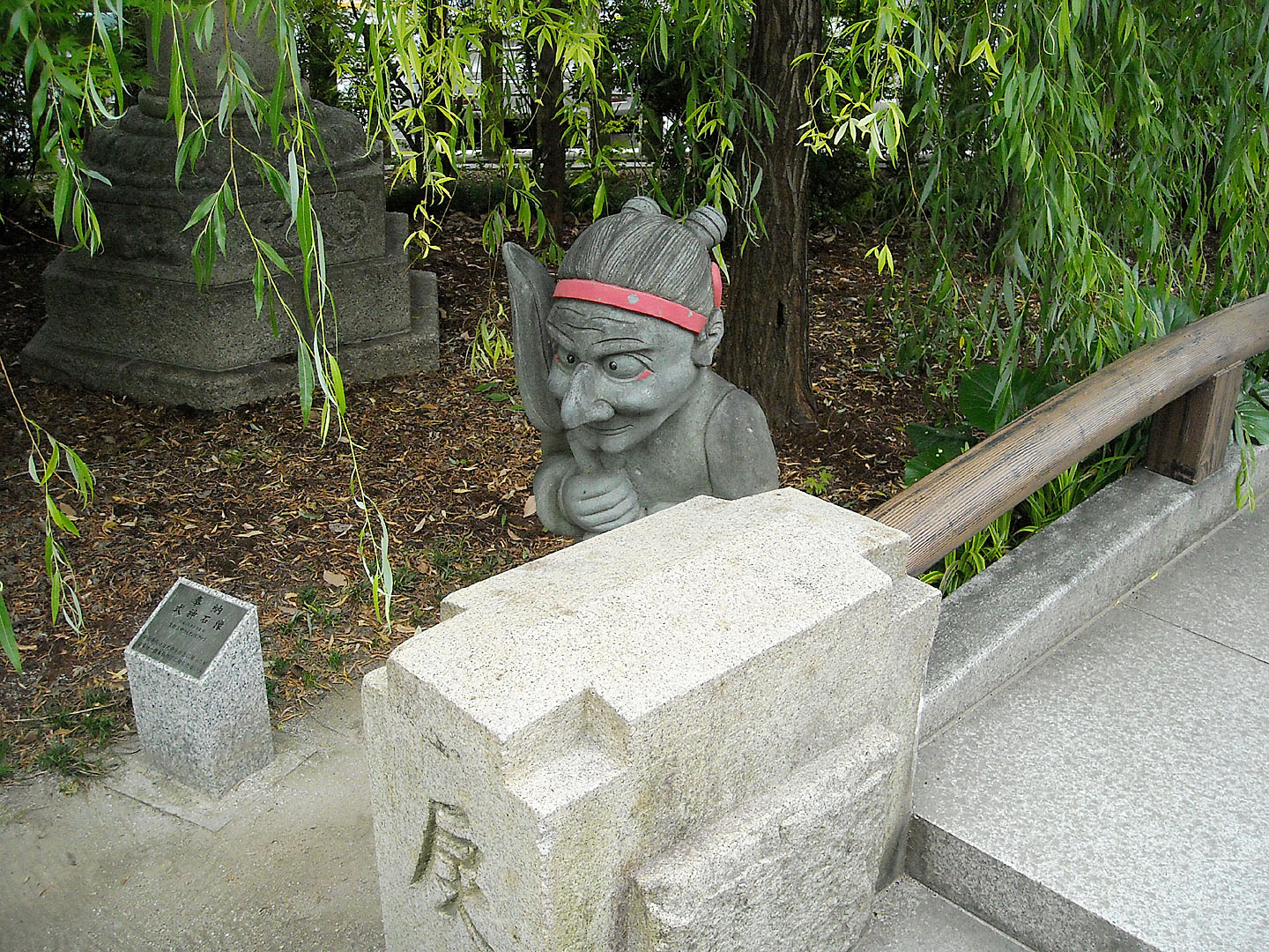 a large statue sitting next to a cement walkway