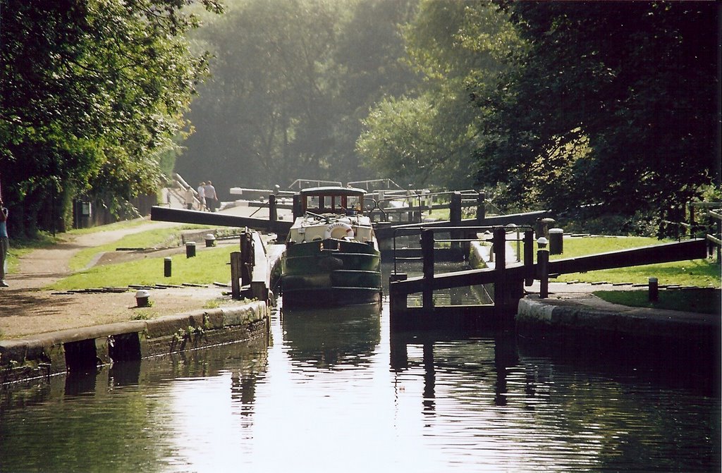 a man and his daughter walk along a canal with boats
