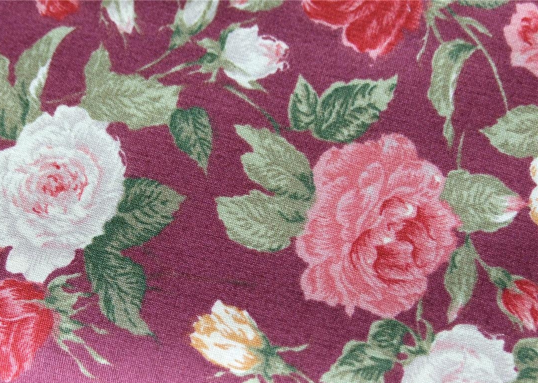 a flowery pink, green and red fabric with flowers on it