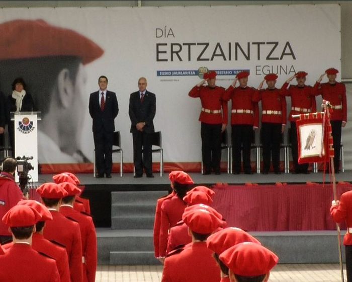people in red uniforms and suits standing near a podium